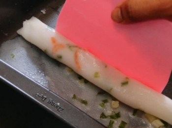 step8: 用平刮把腸粉慢慢卷成條狀，然後剪成數段，食用前可加上芝麻和甜豉油。