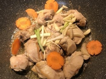 step4: 雞肉上色後，放入蒜片、蔥白與紅蘿蔔片炒出香味；