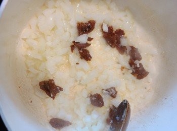 step2: 下油(可用油漬蕃茄乾的油)先將洋蔥炒香至軟身，再加入油漬蕃茄乾和蒜蓉續略炒。