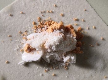 step2: 將白蔥糖切段,捏碎花生酥灑上芝麻椰絲在春卷皮上