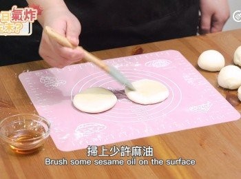 step10: 灑少許麵粉在乾淨工作台上，把麵團滾成長條 切割8等份，每份滾圓，用手輕壓扁，掃上少許麻油。
Sieve some flour on the clean working table,Roll the dough into a long string cut into 8 portions.Roll each dough into a round shape, use your hand to press the dough, then brush some sesame oil on the surfac