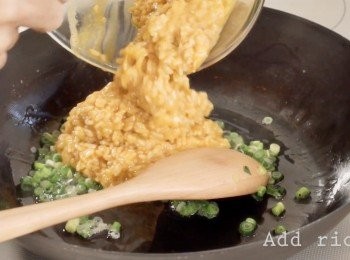 step2: 油熱以後先加入一半的青蔥。
再加入飯，拌炒均勻。
最後炒至飯粒開粒粒分明以加入其餘的青蔥。