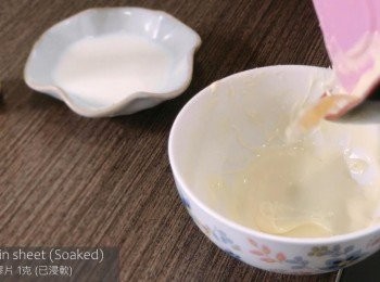 step7: 把白朱古力坐熱水至溶化，加入溫尼拿油、暖牛奶和已浸軟的魚膠片並拌勻。