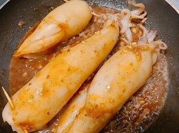 step10: 釀好米飯的魷魚筒連同魷魚鬚放入平底鍋燒煎一下，  加入燒汁燒煮一會兒 ，上色即可把魷魚筒撈出，剩餘的汁再淋回魷魚筒表面伴食，最後撒上芝麻便可享用。
