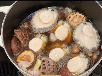 step3: 大鍋下油，中火爆香薑片乾蔥蒜頭，加入冰糖炒2分鐘至溶化，倒入浸菇水，中火煮滾後，放入冬菇和鮑魚，合蓋小火煮40分鐘，再熄火焗30分鐘