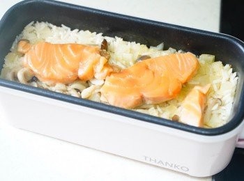 step3: 待米飯煮成半熟後，加入三文魚塊，待萬能盒亮燈轉為綠色，再焗10分鐘。