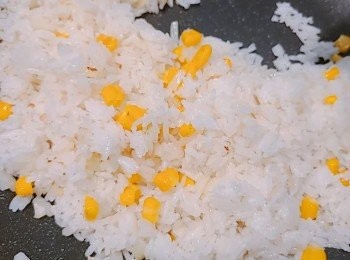 step4: 調中火加入飯和粟米粒，撥散並慢慢炒勻，用鏟背一邊按壓一邊炒飯粒，如是者炒至粒粒分明。　