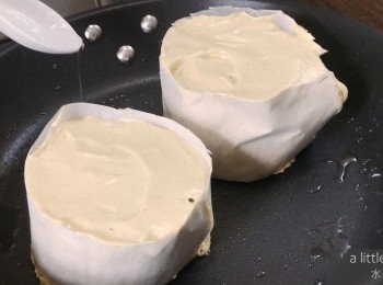 step5: 在平底鍋抹上小許油並用小火預熱2 分鐘，然後把班戟麵糊擠入牛油紙模中，在旁邊加一至兩匙水，加蓋煎焗5-6分鐘，然後把班戟反轉，加蓋再煎焗5-6分鐘。