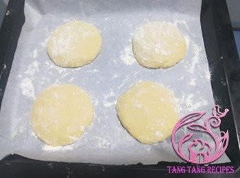 step8: 焗盤放上烘焙紙，上高筋麵粉，把麵糰壓平約10cm直徑，表面撒上薄薄一層高筋麵粉。