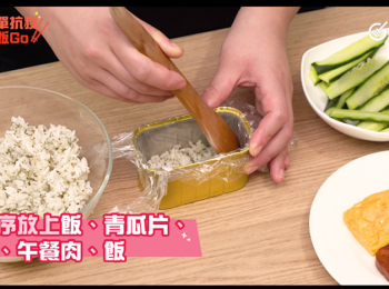 step4: 餐肉盒放上保鮮紙，依序放上飯、青瓜片、蛋、午餐肉、飯，最後放在紫菜上對折。