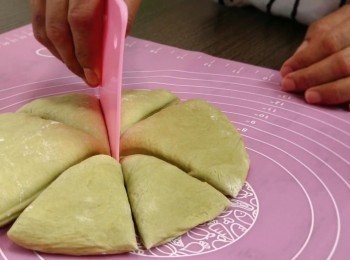 step7: 在桌面灑上麵粉，倒出麵團，用手將麵團中的空氣輕輕擠壓出來，把抹茶和牛奶麵團分別分成8等分，每個麵團滾圓並收口向下，再蓋上保鮮紙，靜置20分鐘以進行第二次發酵。