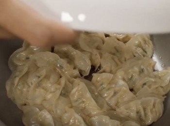 step4: 5分鐘以後加入一點點麻油。
檢查是否熟透。
把盤子放在鍋子上然後把餃子倒出來。
