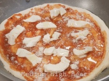 step5: 準備一個平底鍋，放入一點油。
把披薩皮放在鍋中，可以加入自己喜歡的配料。
例如：番茄醬、芝士、香腸⋯⋯

使用中火，然後蓋上蓋子。