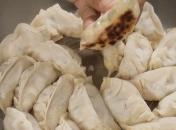 step3: 然後可以開始煎餃子。
在平底鍋中放入一點油。
油熱以後餃子以扇狀的方式放入。
是用中火當餃子底部開始有一點點金黃色，
可以倒入100克左右的水。

把火調至小火然後蓋上鍋蓋
煮大概5分鐘。