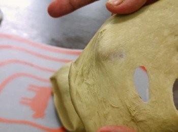 step5: 分別摔打兩個麵團，拉著麵團一角並把麵團摔打在桌面上，重復動作約50次，使麵團呈光滑狀態，而將麵團切開一塊，麵團會慢慢撐出一層薄膜，這樣揉搓的步驟完成。