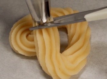 step5: 在焗盤上擠出自己喜歡的形狀。
然後用剪刀剪掉尾部。

擠好形狀以後，
可以在麵團表面塗上牛油，增加香氣。
（此步驟個人喜好）