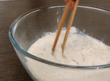 step2: 把麵粉、25克糖、鹽放入碗中拌勻，再加入酵母鮮奶用筷子攪拌，在桌面灑上麵粉，把粗糙的麵團移到桌上，用手腕把麵團揉搓5分鐘至有彈性。
