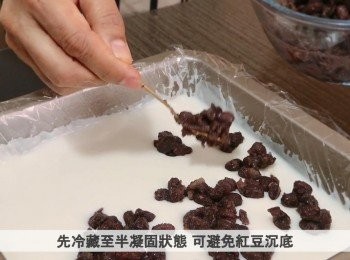 step4: 把一半奶凍漿倒入盤中，放入雪櫃冷藏30分鐘，當奶凍呈半凝固狀態，加入紅豆粒，再冷藏15分鐘，然後把剩餘的奶凍漿倒入紅豆糕上，冷藏30分鐘。