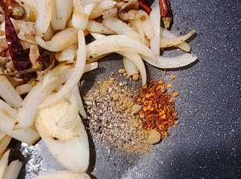 step6: 放回羊肉片，再加入花椒粉、孜然粉和辣椒粉炒勻。