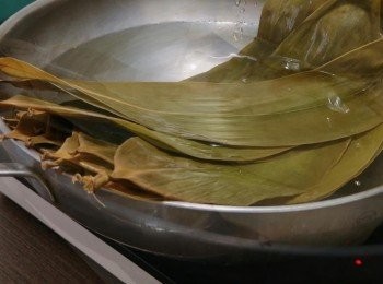 step1: 把乾粽葉用溫水浸1小時，然後用抹布清洗乾淨，把它放入水中煮15分鐘，再把粽葉的頭部和尾部剪掉備用。