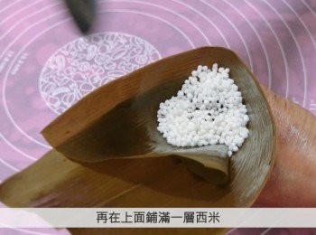 step6: 在粽葉的中央位置窩出一個三角形，在底部放入一層西米，然後加入紫薯餡，再在上面鋪滿一層西米。