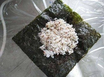 step1: 乾淨砧板上鋪張保鮮膜，將海苔放成菱形，中間鋪一半的熟飯，略整成正方形