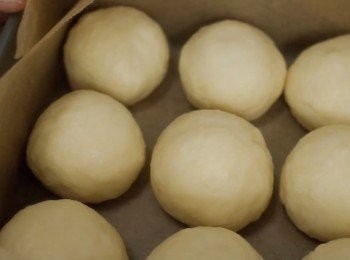 step2: 然後把麵團拿出來，按壓一下。
把麵團中的空氣排出。
然後把它分成九份。搓揉成小圓球。

放在焗模上，蓋上保鮮紙或毛巾。
發酵30分鐘。

我使用的焗模是正四方形15cm
其實你可以使用其他形狀大小也可以喔!

詳細請參考影片：）