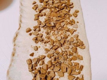 step7: 排氣搓成長方形，平均放上美祿餅碎，卷成長條形，在中間位置𠝹一刀，打結放入吐司模