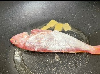 step1: 早上用2/3茶匙粗鹽和胡椒粉搽勻魚肚魚身，臨煎前用水沖走鹽份，印乾水份，薄薄撲上粟粉，用薑片起鑊，煎到一面香脆先翻魚。