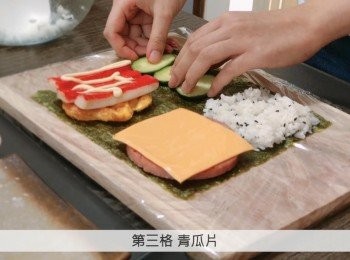 step6: 在砧板上鋪上保鮮紙，然後放上紫菜，在四格上放上不同的<span class="group_1">食材</span>。
第一款: 1.壽司飯 2. 火腿和芝士 3. 雞蛋、吞拿魚和木魚絲加上沙律醬4. 青瓜片
第二款: 1.壽司飯 2. 火腿和芝士 3. 雞蛋和蟹柳加上沙律醬 4. 青瓜片