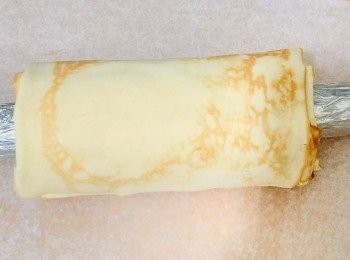 step7: 取出煎好的麵皮，立即把已用錫紙包裹好的木棍放上餅皮卷起，以布蓋起備用