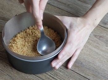 step2: 把餅乾碎倒進鋪好烘焙紙的模具中,並用湯匙壓實,在已預熱攝氏170度焗爐焗12分鐘,放涼備用