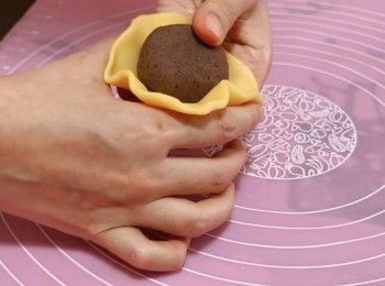 step12: 3) 把餅皮壓平至手掌心大小，包入一顆椰汁<span class="group_2">紅豆餡</span>，把餅皮慢慢推向上封口，輕輕滾圓。把月餅和餅模撒上手粉，放入餅模擠成月餅形狀，然後把月餅放入冰箱冷藏1小時定型。