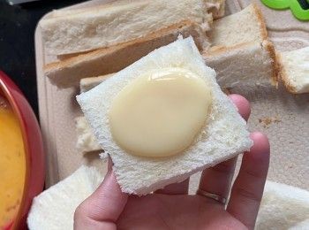 step1: 厚方包去皮後切成正方形，中間位置唧適量煉奶，再與另一塊包夾好。