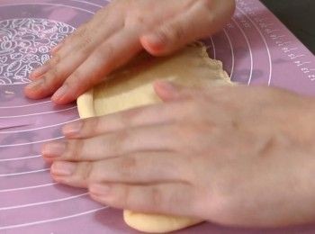 step7: 用棍把小麵團擀成長橢圓形，在較長的一側下方按壓數次固定麵團，把麵團由上而下捲起，把麵團黏緊收口，用手輕輕擀成適當大小的長方條。