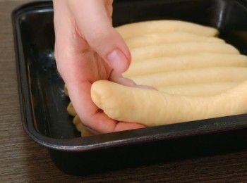 step8: 在烤盤塗上牛油防黏，把麵團平均排放在烤盤上。把麵團放入沒有開啟的焗爐，在下層放入一碗60度的熱水，發酵45分鐘。