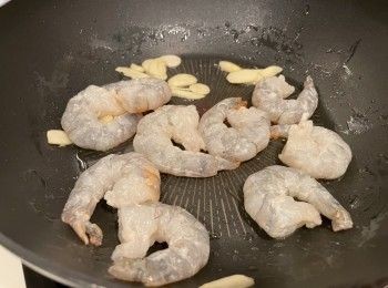 step3: 用油爆香蒜片，加入蝦仁，炒到蝦半熟後，贊酒略炒，蝦仁盛起