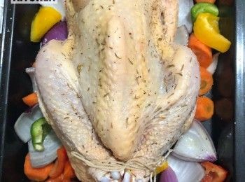 step3: 用綿繩綁好雞腿位置，整隻雞放於鋪滿蔬菜的焗盤上。