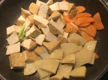 step6: 放入紅蘿蔔片、筍片和油豆腐拌炒；