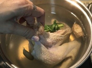 step10: 抓住雞脖子，將雞重複沾浸到高湯裡，浸ㄧ下拉起來，直到高湯溫度降到80度；