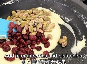 step2: 加入蔓越莓干、杏仁、开心果，迅速翻拌几下。倒入饼干。简单翻拌一下后把雪花酥团倒入烤盘内，