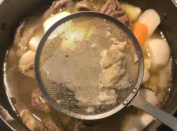 step5: 將煮好的高湯濾入湯鍋中，也將煮牛腱子心的五香包也換放入湯鍋中，並將蒜頭用濾網壓成泥溶入湯鍋中一起煮；