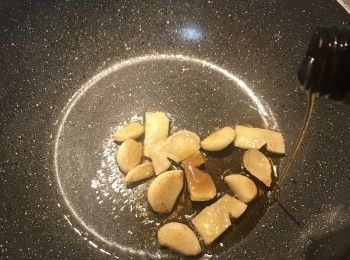 step5: 鍋燒熱，放少許優質橄欖油，下薑片與蒜頭炒香；再放入黑麻油；