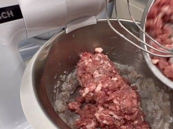 step5: 於是便可以將免治豬肉（我用了梅頭半肥瘦絞碎），加入蝦膠裡。加入生粉（ 20克）和豬油（一湯匙），然後分次加入冬菇水（120毫升），繼續以高速打至全起膠狀態。