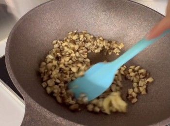 step4: 在鑊中加點油，落一粒蒜頭，將冬菇粒爆香備用。