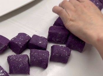 step7: 將紫薯粉團，由碗倒到工作枱上，搓揉1至2分鐘，以讓糯米粉與紫薯泥搓勻。
然後就可以將粉團，平均地分成每粒大約35至40克的小粉團，搓圓備用。
