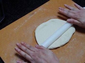 step7: 把麵糰放在灑了粉的板上； 用麵棒滾成圓型薄片; 想Pizza薄點可將麵團稍擀薄一點。 

**Tips：  批底麵團不要太厚； 因麵團在烤焗期間會澎漲一點點的