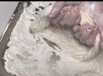 step10: 大概扭了10多次的模樣，慢慢呈現幼絲，注意了，期間要把「龍鬚」不停撲上糯米粉，使龍鬚一絲絲分明。
「打8字」法，建議最少打13次或以上，才有較好看的拉絲效果。