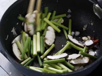 step2: 燒熱油，爆香乾葱、紅椒和蒜頭，加入冬菇同炒勻，再加入蒜心。
Heat the oil, stir fry shallot, chilli, garlic and shiitake mushroom. Put in garlic shoot and stir fry.