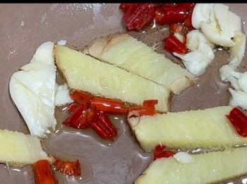 step8: 預備電飯煲，將蒜頭、薑片和辣椒以及油，加到電飯煲內，開啟並蓋上電飯煲，等候5至10分鐘，讓以上的配料得以爆香。